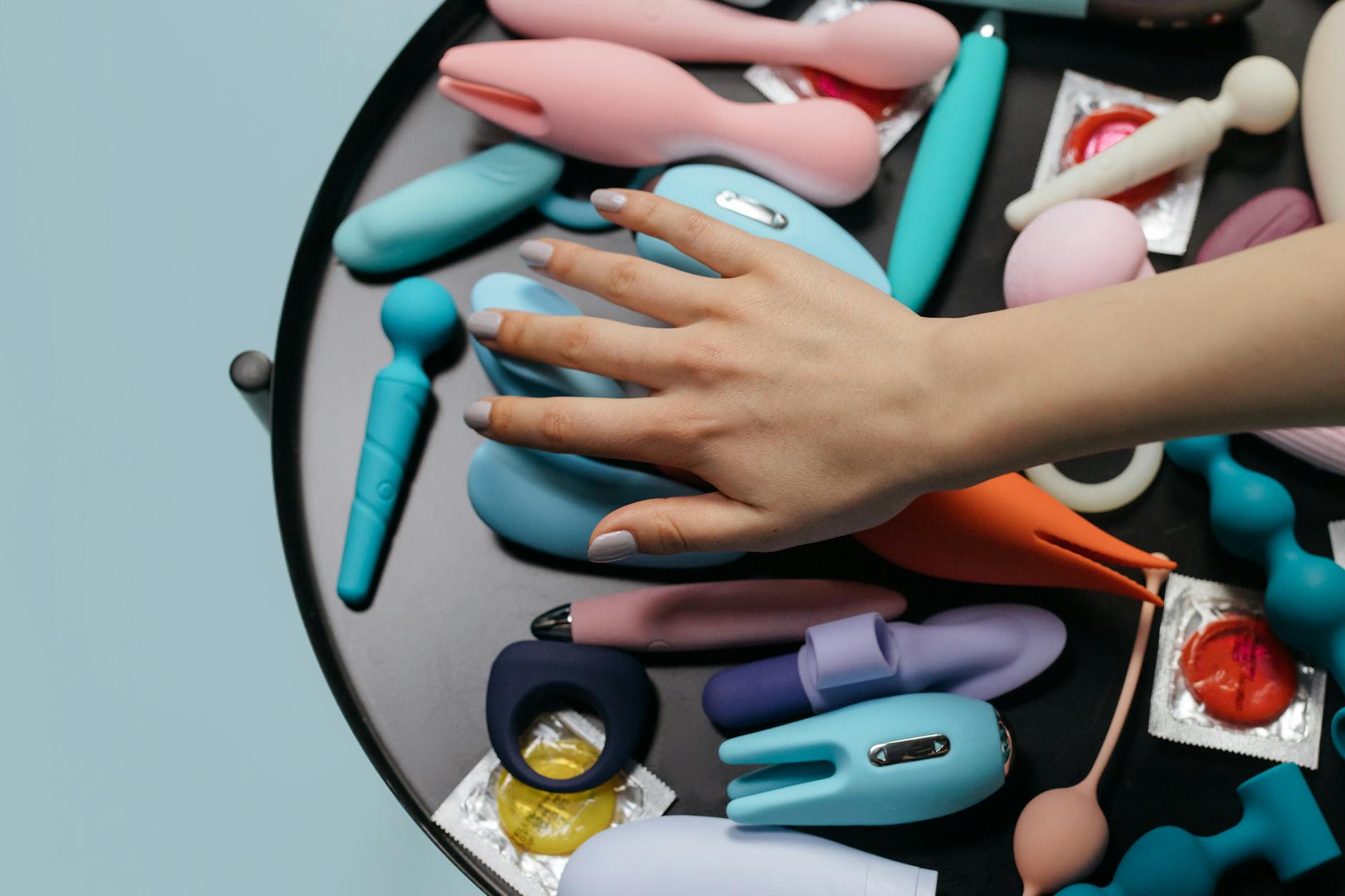 Three vibrators arranged on white fabric, showing different designs and colors