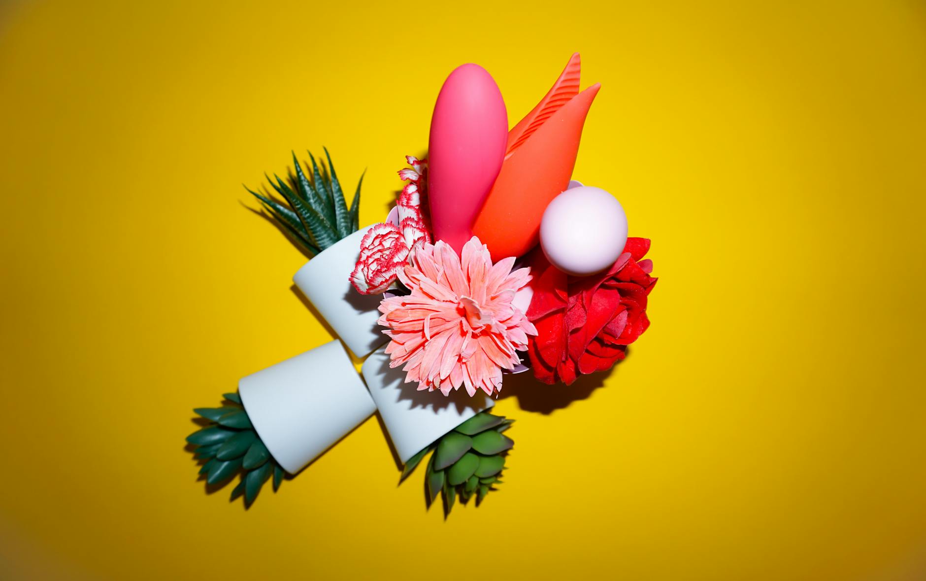 Hand holding a fresh lemon against a soft pink background surrounded by additional lemons